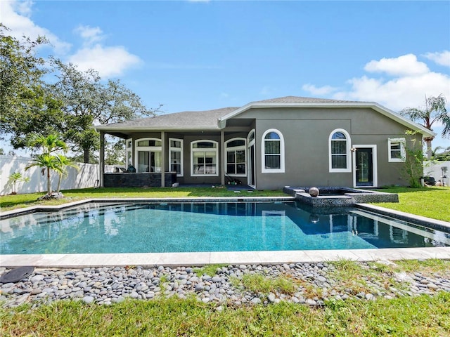 rear view of house with a fenced in pool and a yard