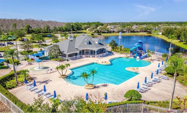 view of swimming pool featuring a patio, a water view, a playground, and a water slide