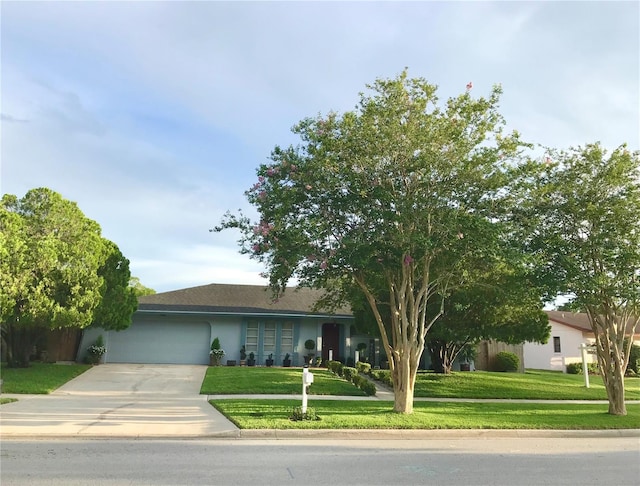 view of front facade with a garage, stucco siding, driveway, and a front lawn