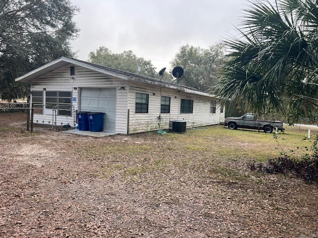 view of property exterior with a garage and central AC