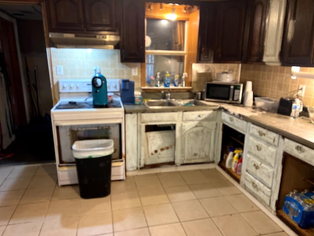 kitchen featuring sink, decorative backsplash, white electric range oven, light tile patterned flooring, and dark brown cabinets