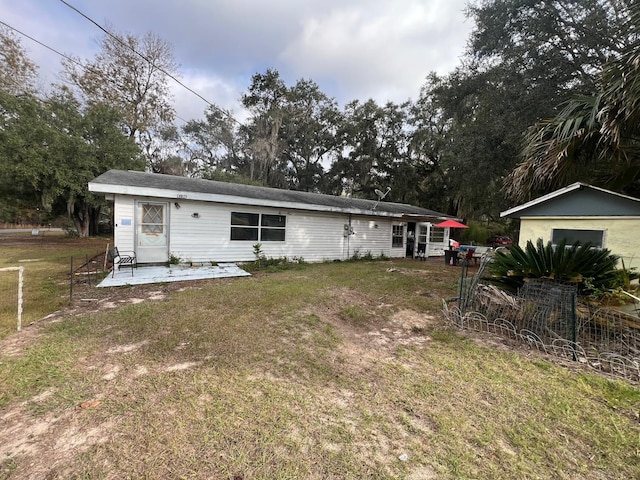 back of property with a patio area and a lawn