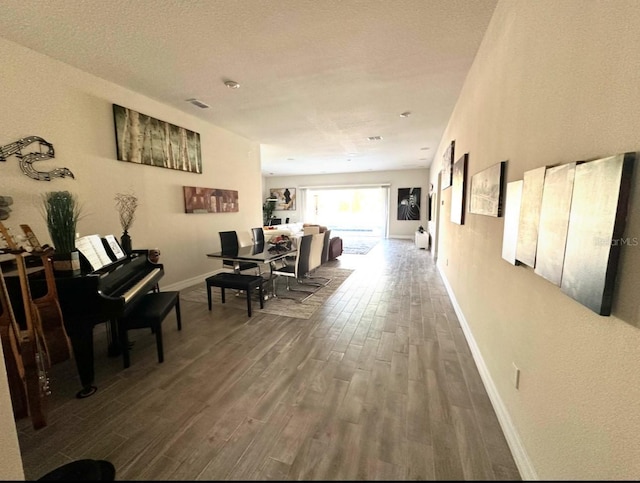 corridor featuring a textured ceiling and dark hardwood / wood-style floors