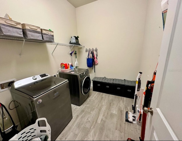 laundry room featuring washer and dryer and light hardwood / wood-style flooring