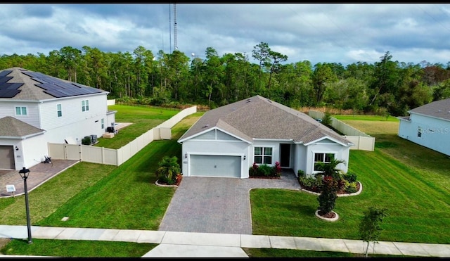 ranch-style home featuring a front lawn, fence, decorative driveway, an attached garage, and a gate