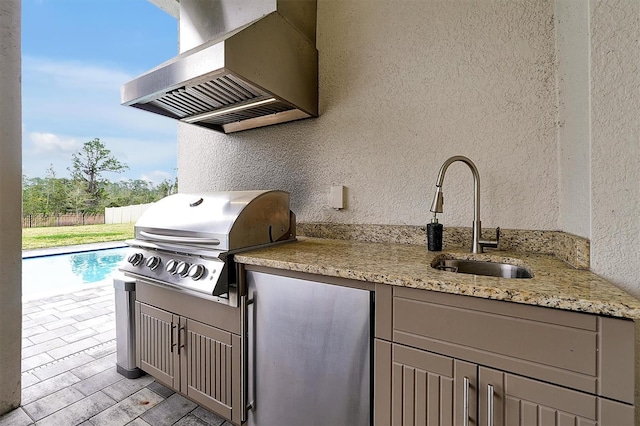 view of patio / terrace featuring a grill, exterior kitchen, fence, and a sink