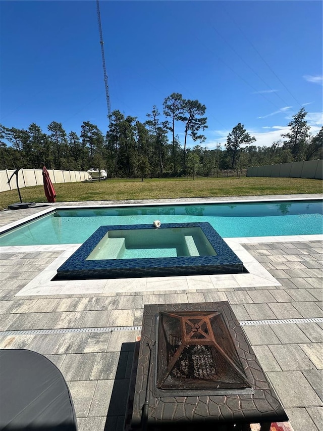 view of swimming pool with a patio area, a pool with connected hot tub, a yard, and fence