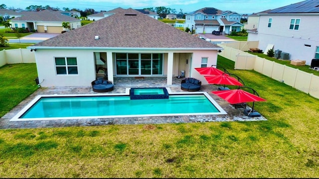 back of house featuring stucco siding, a lawn, a fenced backyard, a residential view, and a patio area