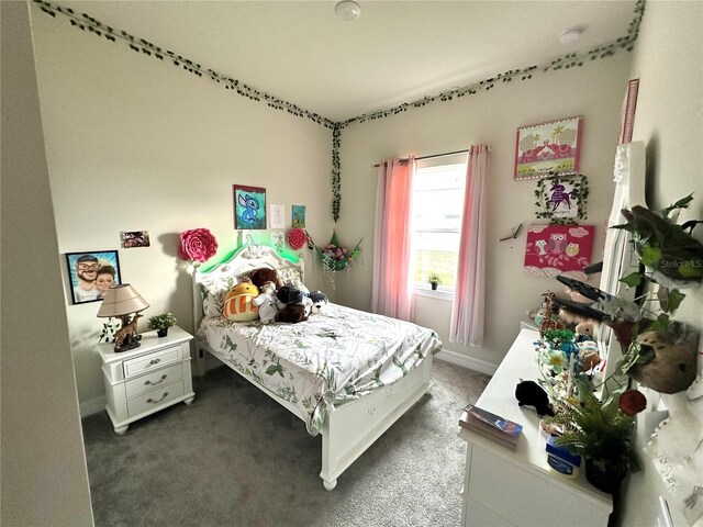 bedroom with baseboards and dark colored carpet