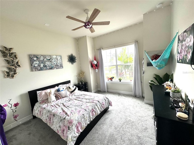 carpeted bedroom with ceiling fan and baseboards