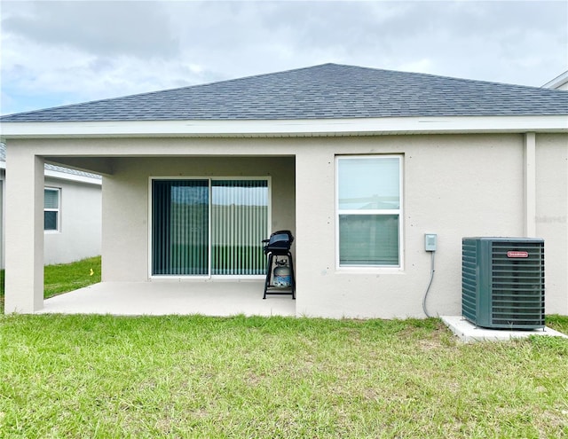 back of house with central AC unit, a yard, and a patio