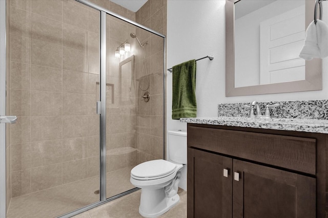 bathroom featuring tile patterned floors, a shower with door, vanity, and toilet