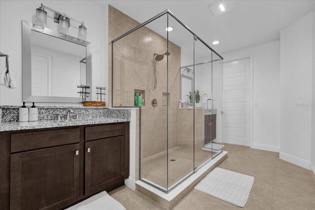 bathroom with tile patterned flooring, vanity, and an enclosed shower