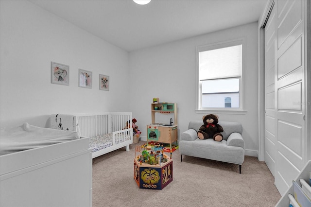 bedroom featuring a crib and light carpet