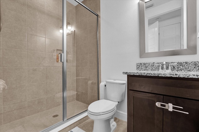 bathroom with tile patterned floors, a shower with door, vanity, and toilet