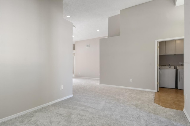 empty room featuring separate washer and dryer and light colored carpet