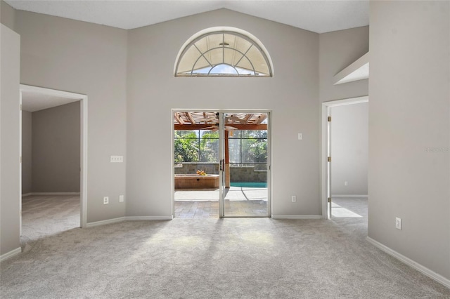 interior space featuring high vaulted ceiling and light carpet