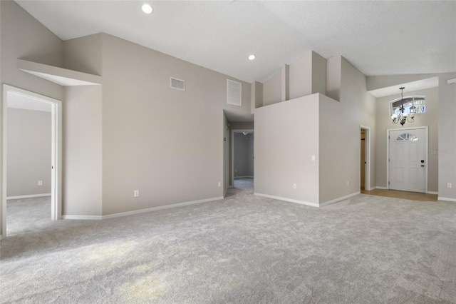 unfurnished living room featuring a textured ceiling, light carpet, a notable chandelier, and high vaulted ceiling