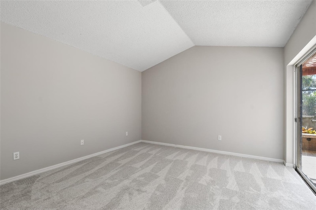 carpeted empty room with lofted ceiling and a textured ceiling