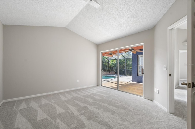 empty room featuring lofted ceiling, a textured ceiling, and carpet