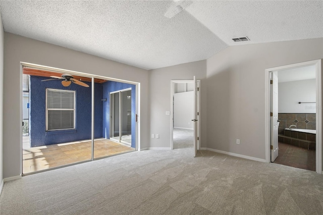 unfurnished bedroom with ensuite bath, lofted ceiling, carpet, and a closet