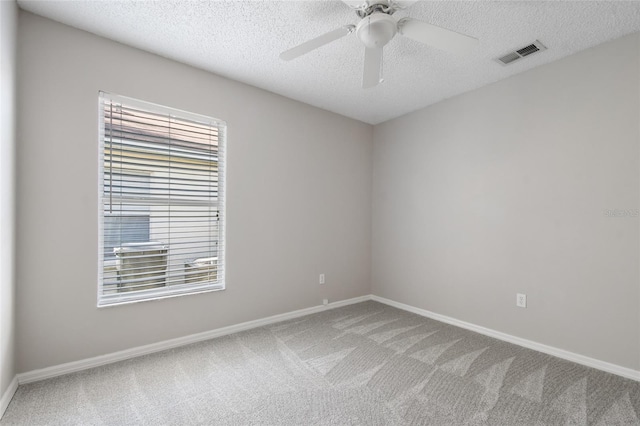 carpeted spare room with ceiling fan and a textured ceiling