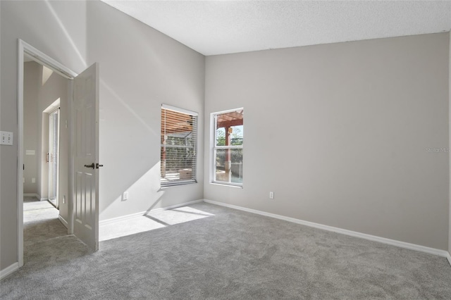 carpeted spare room with a textured ceiling