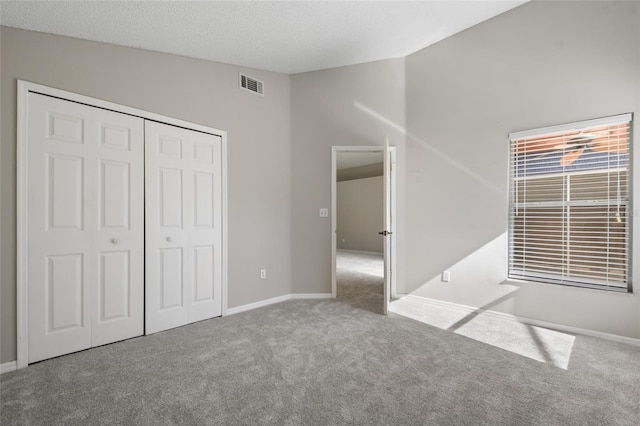 unfurnished bedroom featuring lofted ceiling, a closet, and carpet flooring