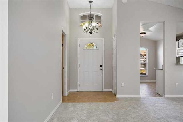 carpeted foyer entrance with vaulted ceiling and a notable chandelier