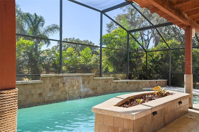 view of swimming pool with pool water feature, a lanai, and a fire pit