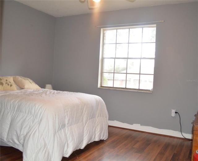 bedroom with dark wood-type flooring, ceiling fan, and multiple windows