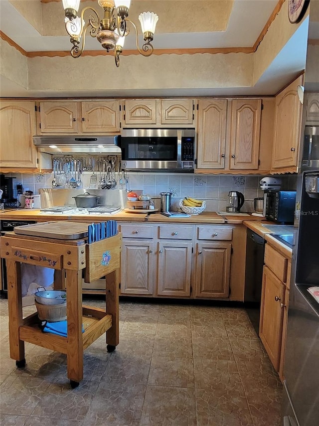 kitchen featuring tasteful backsplash, dishwasher, a raised ceiling, and an inviting chandelier