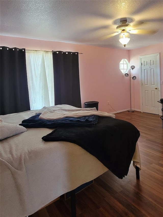 bedroom featuring hardwood / wood-style floors, a textured ceiling, and ceiling fan