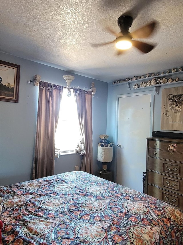 bedroom with a textured ceiling and ceiling fan