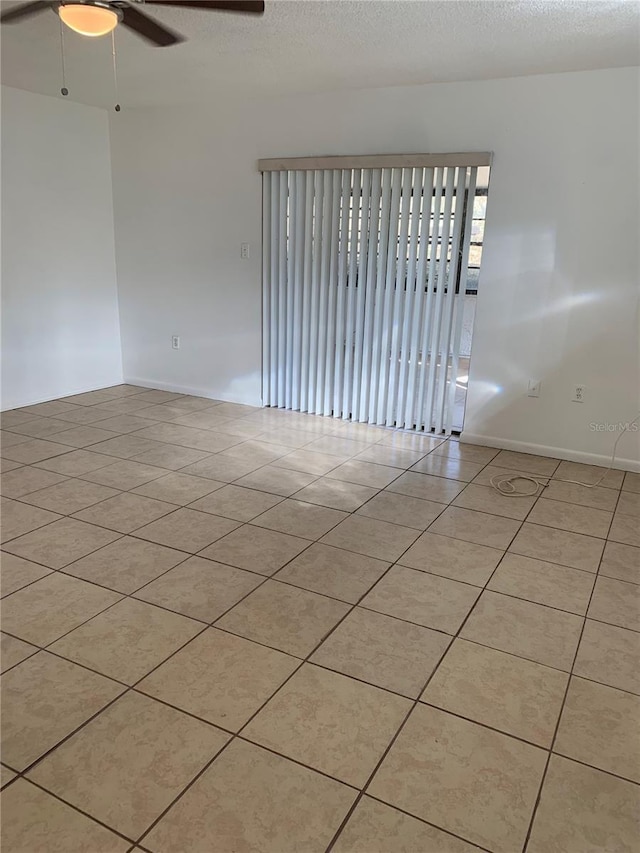 tiled empty room featuring a textured ceiling and ceiling fan