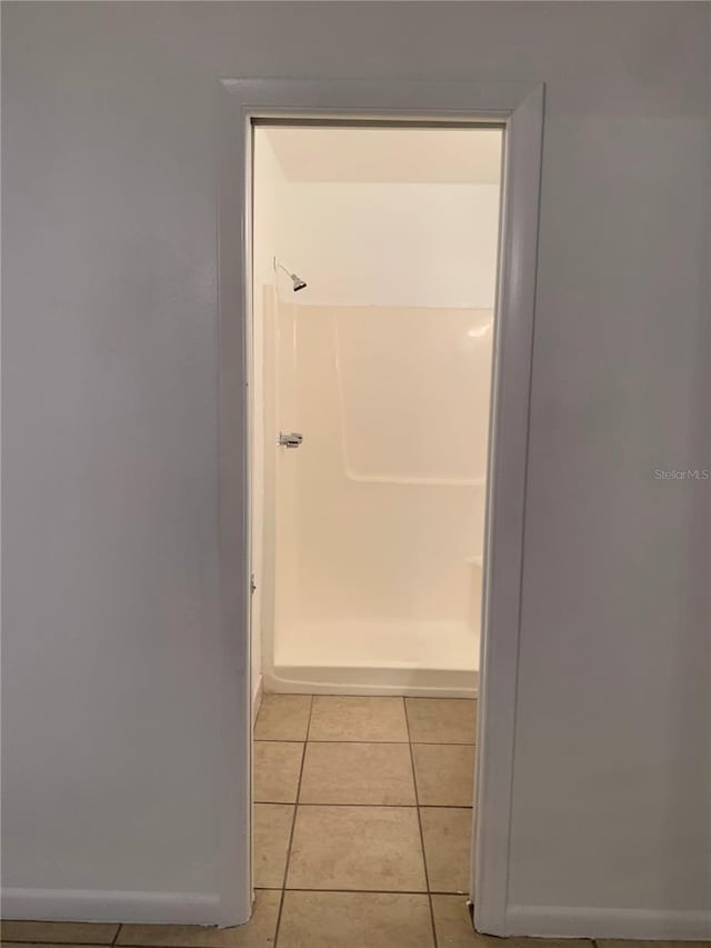 bathroom with a shower and tile patterned floors