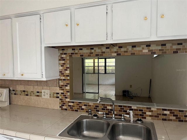 kitchen featuring white cabinets, backsplash, and tile countertops