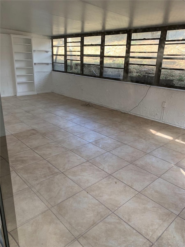 spare room with built in features and light tile patterned floors