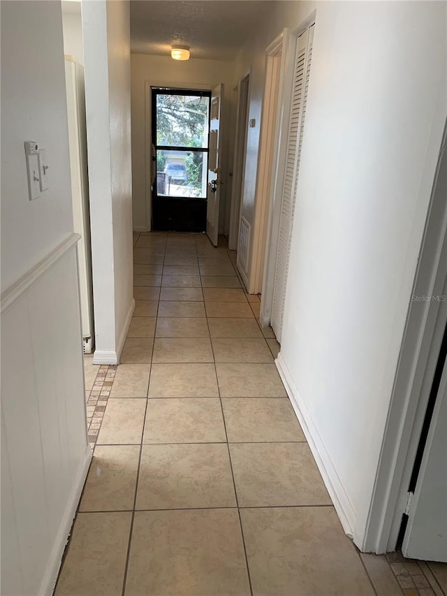 hall with light tile patterned floors