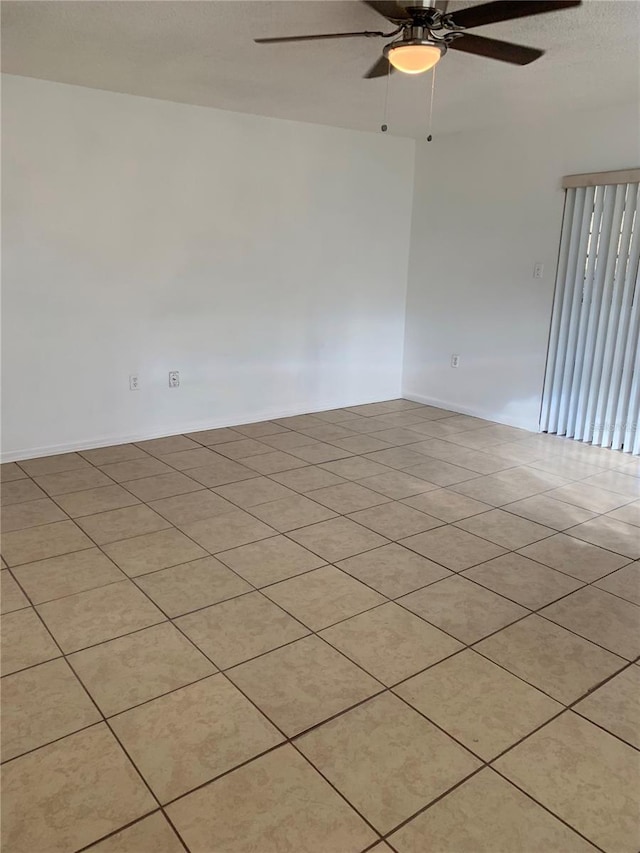 tiled spare room featuring ceiling fan