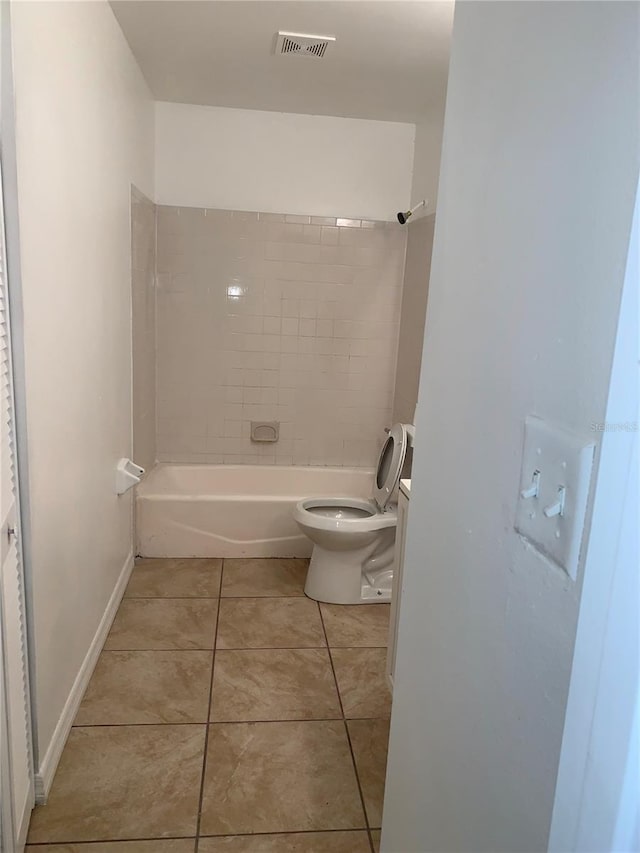 full bathroom with tile patterned floors, vanity, tiled shower / bath, and toilet