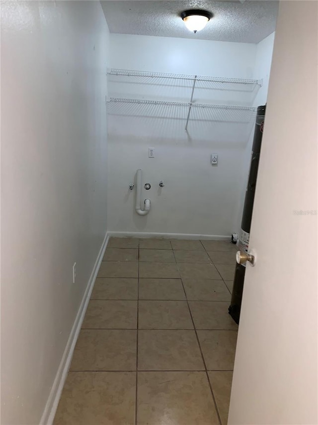 laundry room featuring hookup for an electric dryer, a textured ceiling, hookup for a gas dryer, and tile patterned flooring