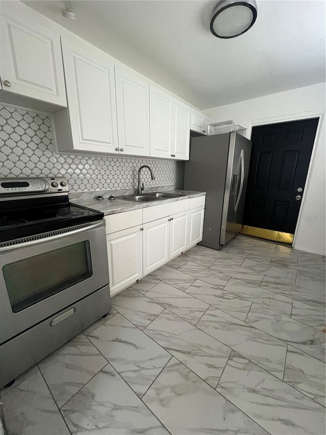 kitchen with backsplash, white cabinetry, sink, and stainless steel appliances