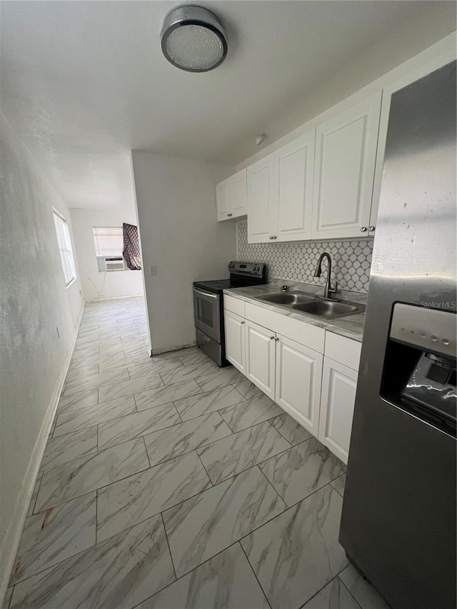 kitchen with backsplash, white cabinetry, sink, and appliances with stainless steel finishes