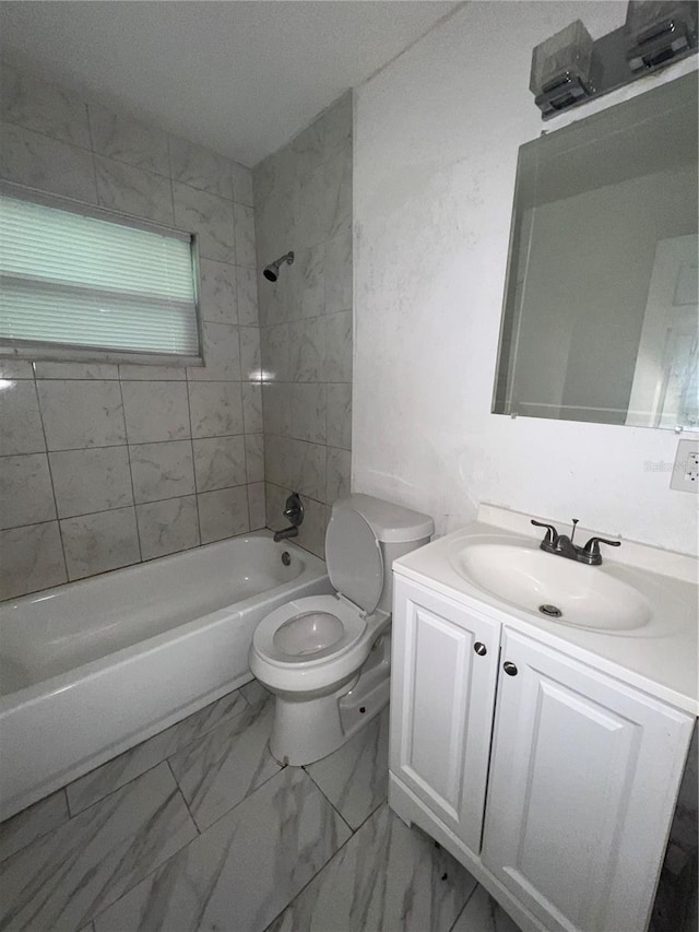 full bathroom with vanity, tiled shower / bath combo, and toilet