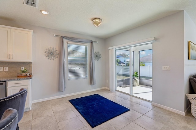 entryway featuring a wealth of natural light, light tile patterned flooring, visible vents, and baseboards