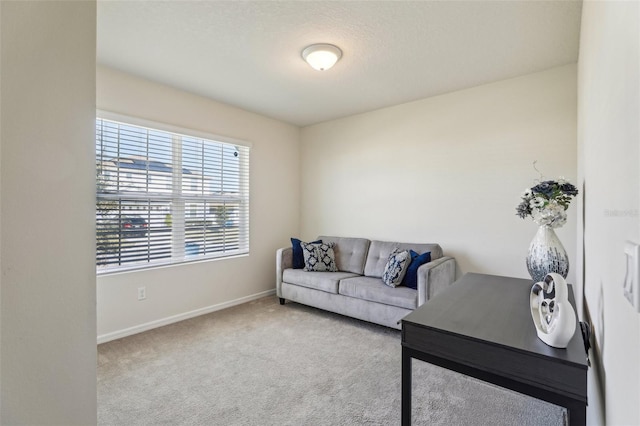 carpeted living area featuring baseboards