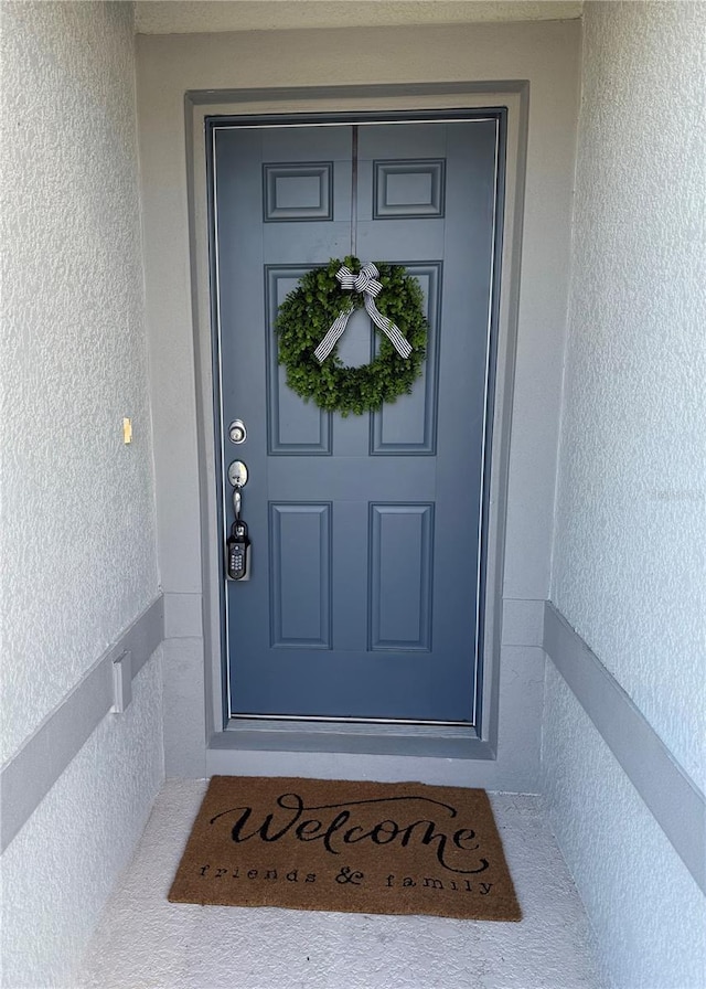 entrance to property featuring stucco siding