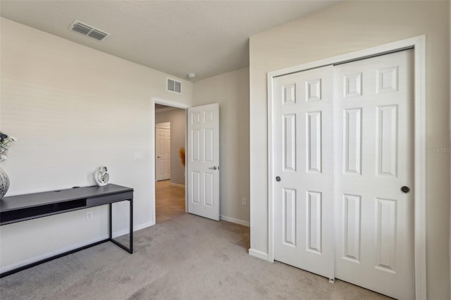 carpeted bedroom with a closet, visible vents, and baseboards