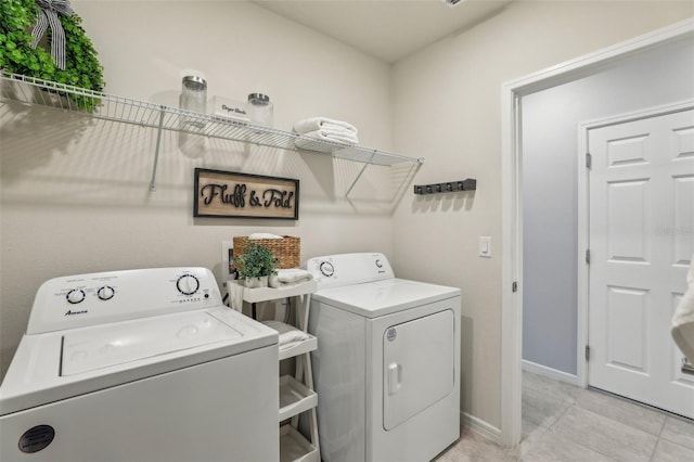 washroom featuring laundry area, light tile patterned floors, baseboards, and separate washer and dryer